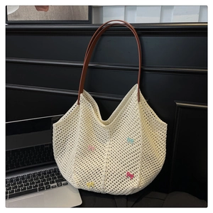 Detail of woven tote bag featuring colorful bow decorations and brown leather strap