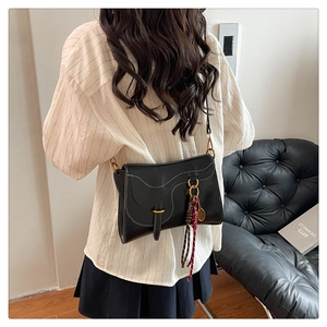 Detailed back view of a black saddle bag with white contrast stitching and silk scarf
