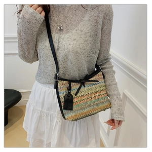 Detail of colorful woven shoulder bag with wavy texture and black leather accents