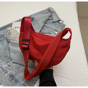 Detail view of red nylon crescent bag texture and adjustable wide fabric strap