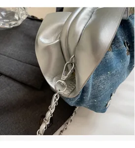 Detailed macro of silver metal hardware and blue denim fabric with sparkling rhinestones