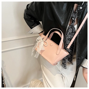 Mini borsa a secchiello rosa con fiocco in pizzo e perle portata a tracolla