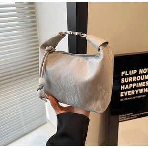 Detail der silbernen Hobo-Tasche mit Falten-Struktur und dekorativen Kugelperlen