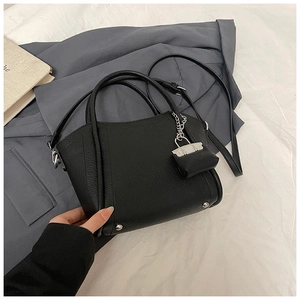Close-up of black litchi grain leather bucket bag with silver hardware and mini coin purse