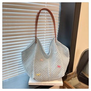 Detail view of light blue hand-woven crochet tote bag with colorful 3D ribbon bows