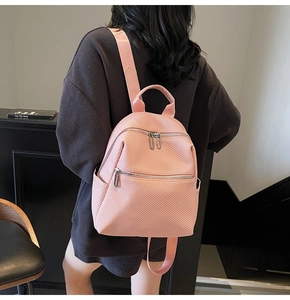 Detail showing back view of pink mini backpack with silver zippers and textured fabric