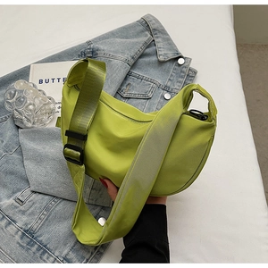 Detail of a bright green nylon crescent bag with adjustable wide fabric shoulder strap