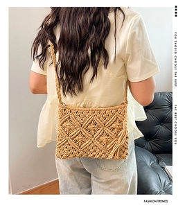 Detail of hollow knit crossbody bag with diamond weave and decorative long side tassels