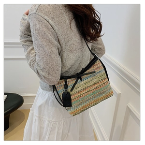 Detailed view of woven shoulder bag with colorful wave patterns and a fashion tag