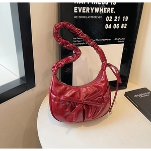 Détail de la poignée froncée bordeaux et du cuir PU plissé brillant sur le sac de mode
