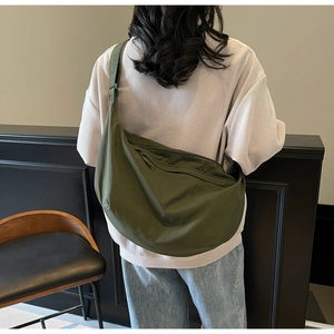 Olive green crescent shoulder bag showing large capacity and adjustable strap