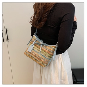 Colorful woven crossbody bag with light blue leather strap and decorative bow detail