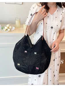 Summer black woven tote bag with colorful bows and brown handles for beach vacations