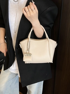 Cream lychee leather handbag with twin handles and mini bag charm accessory