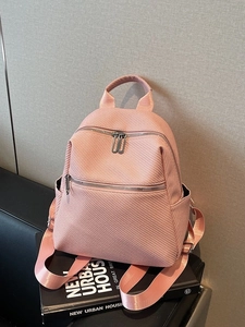 Pink honeycomb woven faux leather backpack with adjustable straps and front zip pocket