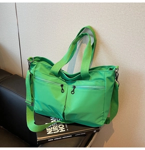 Detail of bright green nylon tote bag featuring durable handles and adjustable shoulder straps