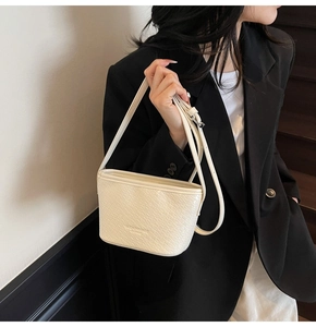 Close-up of cream white woven texture leather on a stylish bucket shoulder bag for women