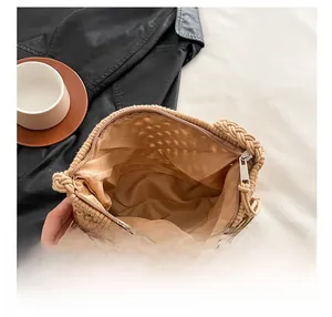 Detail view of khaki knit crossbody bag with metal zipper and smooth brown fabric lining