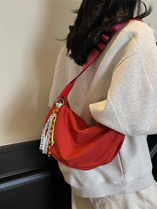 Versatile red half-moon crossbody canvas bag with adjustable wide strap and charm