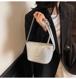 Close-up of silver bucket bag showing intricate woven texture and brand logo detail