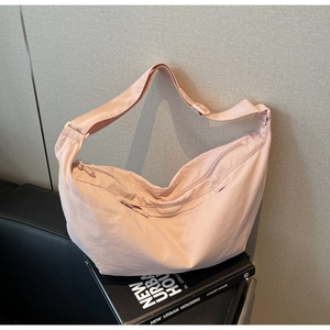 Close-up of pink nylon crescent bag with adjustable strap and textured fabric detail