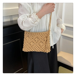 Detail view of khaki crochet shoulder bag with diamond patterns and long tassels on the side