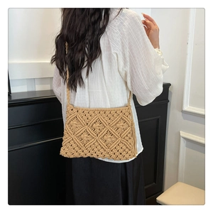 Detail of beige macrame crochet bag featuring geometric patterns and side tassels