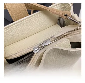 Close-up of premium lychee texture leather bag with high-quality silver zipper hardware