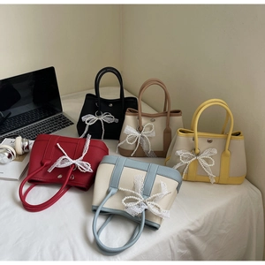 Five colors of canvas and PU leather handbags featuring pearl bow charms and twin handles
