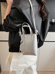 Mini silver metallic tote bag with crossbody strap and cute dog charm for women