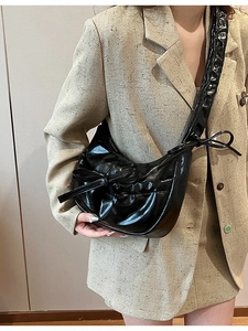 Sac croissant noir brillant avec design plissé et détails de nœuds pour femme