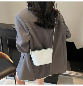 Close-up of soft white woven leather texture on a stylish crossbody shoulder bag