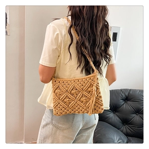Detail of bohemian hollow-out knit cotton crossbody bag with tassel and zip closure