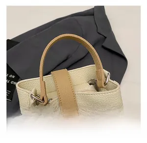 Detail of lychee pattern leather bucket bag with top handle and metal lock closure
