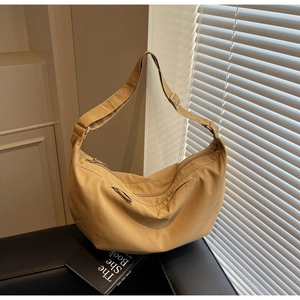 Detail of khaki crescent crossbody bag with wide adjustable strap and zipper closure