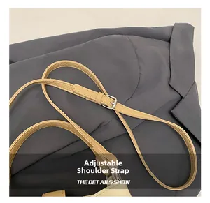 Close-up of adjustable beige litchi leather strap with silver metal buckle on handbag