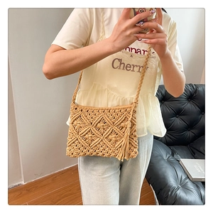 Detailed close-up of bohemian khaki knit bag with hollow diamond patterns and fringe