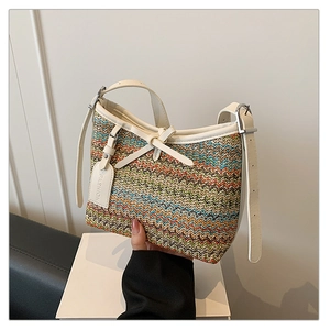 Detail of colorful woven shoulder bag with leather trim and decorative fashion tag