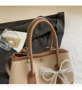 Detail of canvas garden bag with leather stitching and elegant pearl lace bow accessory