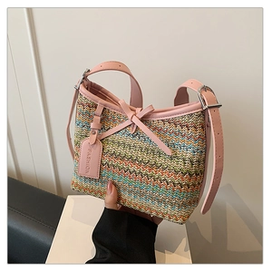 Detail showing colorful woven straw texture and pink leather trim with metal buckles