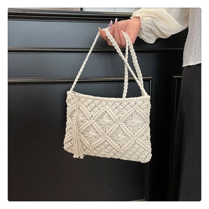 Detailed close-up of white crochet handbag showing 3D diamond weave and side tassel fringe