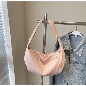 Pink minimalist crescent shoulder bag with front zipper pocket and adjustable strap