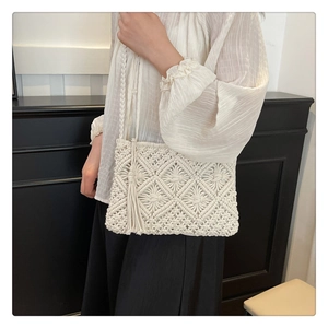 Detail of bohemian ivory macrame crossbody bag with fringes and geometric woven pattern