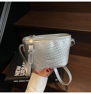 Macro detail of silver woven texture and brand logo on the chic bucket crossbody bag