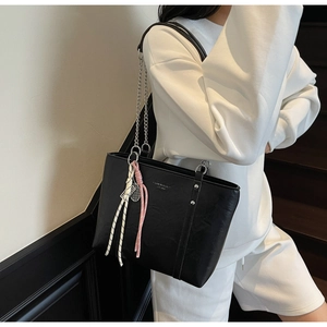 Detail of black PU leather tote with lychee texture and silver chain strap