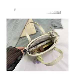 Top view of compact beige bucket bag showing interior space with phone and lipstick