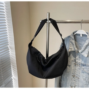 Detail of minimalist black nylon crescent bag with adjustable wide shoulder strap