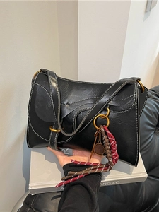 Classic black faux oil wax leather saddle bag with white stitching and tennis racket charm