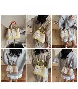 Detail view of the yellow and khaki crossbody bucket bags with lace pearl bow accents