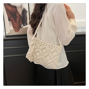 Detail of macrame shoulder bag showing diamond knit pattern and long side tassels